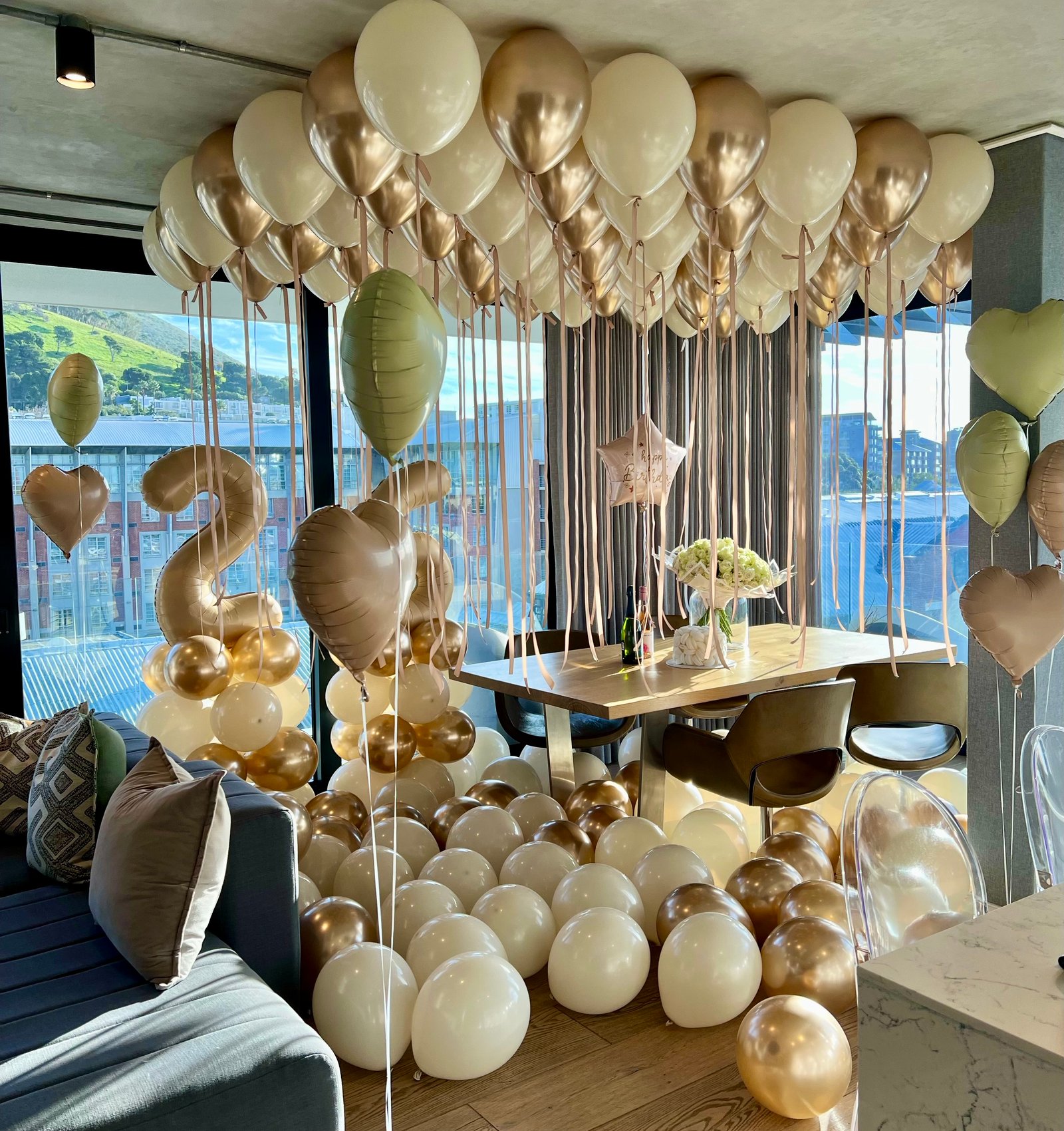 Gold and ivory balloon styling above a dining table